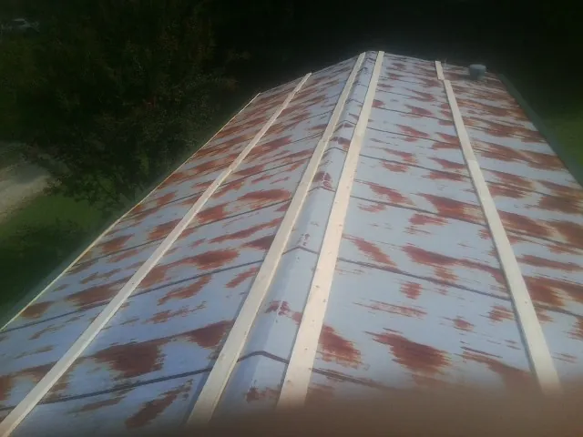Rusted metal roof panels with new wood purlins before replacement — Storm Damage Roof Repair in Fairhope by Roofing Brothers