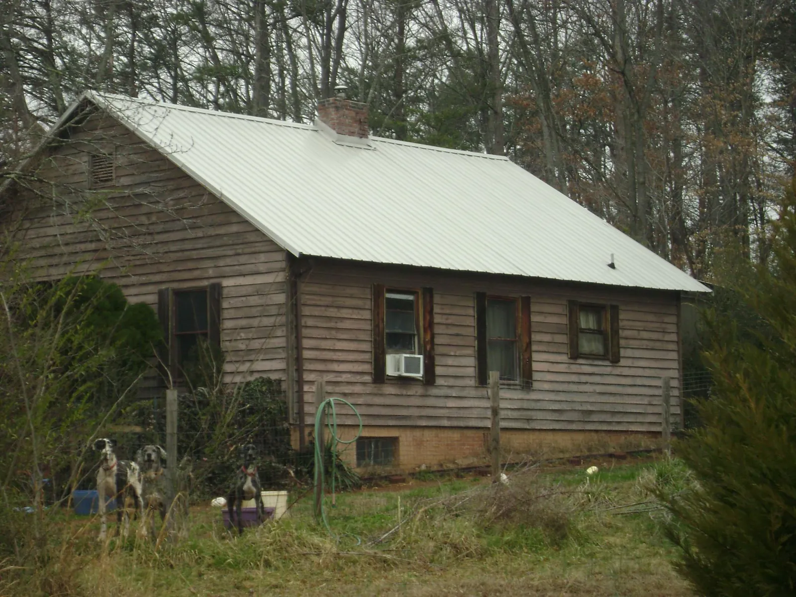 White metal roof on an old wood sided farmhouse, from a Metal Roof Installation job in Fairhope